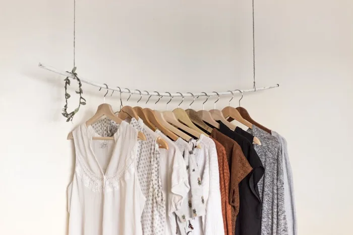 A clothing rack showcases neutral blouses and tops as part of our fashion design services.